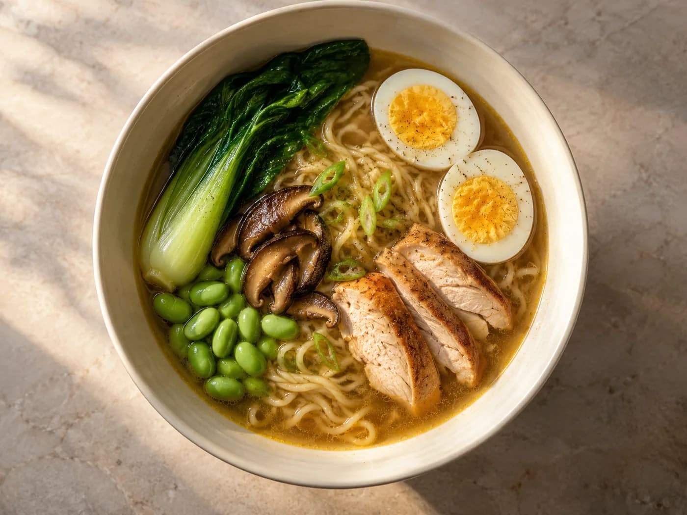 One complete chicken ramen bowl viewed from above with noodles, egg, edamame and vegetables